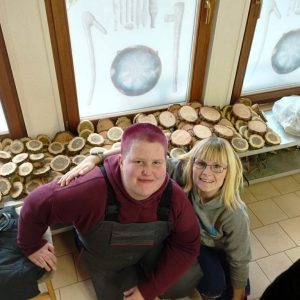 Selina und Melissa arbeiten fleißig für die Töpferwerkstatt: die angefertigten Baumscheiben dienen später als Unterlage für Kleinkunst.